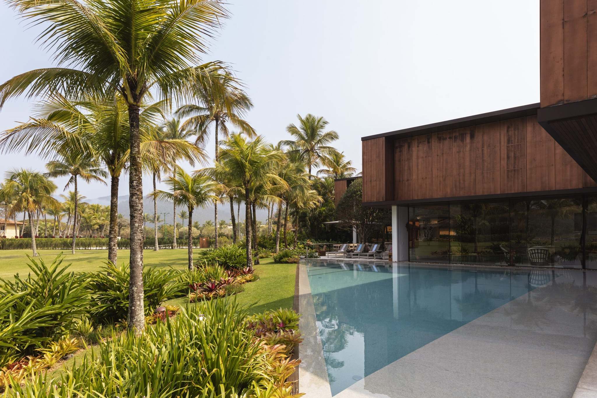 Thiết kế hồ bơi được tích hợp trong khuôn viên sân vườn của biệt thự 2 tầng phong cách tropical